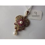 An attractive pearl and ruby pendant set in 9ct.