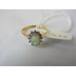 Oval opal and diamond cluster ring set in gold, size M