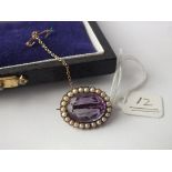 An antique oval amethyst and pearl bordered brooch set in 9ct.