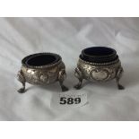 Pair of Victorian small circular compressed salts with floral decorated sides, each raised on hoof