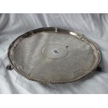 LARGE GEORGIAN CIRCULAR SALVER with beaded floral rim enclosing scroll engraved centre, raised on