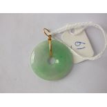 A circular Chinese jadeite round pendant with 18ct gold mount 4.7g