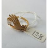 An unusual ring in 18ct in form of a hand holding white stone Size P 3gm