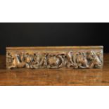 A Late 16th Century Carved Oak Drawer Front decorated with undulating scrolls of husk flowers and