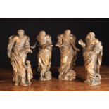 A Set of Four 17th Century Wood Carvings of the Evangelists wearing billowing robes;