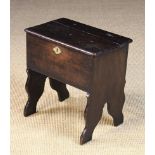 An 18th Century Boarded Oak Box Stool having a hinged rectangular lid and shaped supporting ends