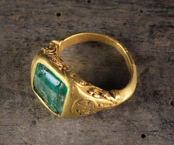 A French Mediaeval Gold Ring set with an emerald (A/F) and decorated with scrolling stems of ball