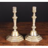 A Pair of 18th Century Silvered Brass Candlesticks engraved with decoration.