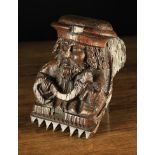 A 16th Century Oak Figural Corbel carved as the head & shoulders of a bearded man depicted with