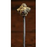A 16th Century Gilt Metal Cloak Pin; the ornamental finial inset with small semi-precious cabochons.
