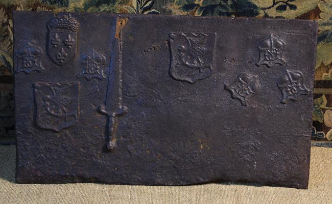 An Unusual 16th/17th Century French Iron Fire Back cast with various armorial shields and a dagger,