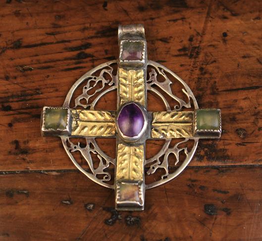 A Silver Pendant Celtic Cross enriched with gold overlay embossed with leaves and centred by an