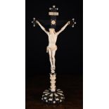 An Early 19th Century Carved Ivory Corpus Christi on an ebony cross with turned ivory adornments,