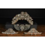 Four 17th Century Style Carved Ornamental Appliqués: A pediment piece with a winged cherubs head