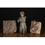 Three Small 17th Century Fragment Carvings: A section of drawer front carved with a winged cherub