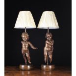 A Pair of Carved Oak Figural Lamps incorporating late 18th Century oak putti above later circular