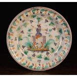 A 19th Century Continental Polychrome Glazed Terracotta Plate decorated with an imbiber sat astride