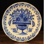 A Late 18th Century Blue & White Delft Charger painted with an urn of flowers to the centre,