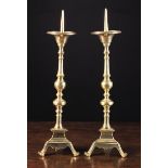 A Pair of 18th Century Brass Pricket Candlesticks with slender knopped stems above triangular bases