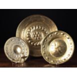 A 15th Century Style Brass Alms Dish embossed with a rosette within wrythen gadrooning to the