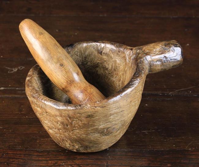 A Small 18th Century Dug-out Treen Mortar with protuberant side handle and accompanying pestle.