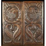 A Pair of 16th Century Style Carved Oak Panels depicting birds encircled by laurel wreaths above