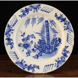 An 18th Century Blue & White Delft Charger decorated in the chinoiserie style with flowers and