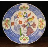 A Large Delft Polychrome Plate decorated with a bird perched upon a spray of flowers within a blue