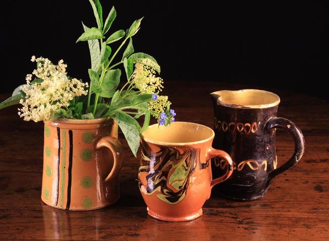 Three Decorative 19th Century French Slipware Jugs with yellow glazed interiors: One with marbled