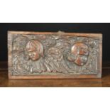 A 17th Century Oak Panel carved with two winged cherub heads of slightly tapered rectangular form,