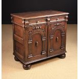 A 17th Century Oak Cupboard housing a moulded frieze drawer with oval brass knop handles above