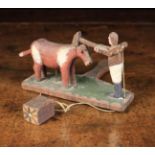 A Delightful Antique Carved Wooden Folk Art Toy with a hand-held paddle surmounted by an