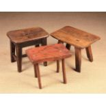 Three 19th Century Country Stools: One having a rectangular slab seat pierced by four stick legs