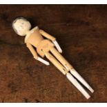 A Carved Pine Peg Doll with painted head, articulated arms and legs, 11½" (29 cm) in length.