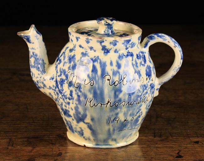 A Wetherigg's Pottery Teapot with stippled blue glaze on a cream glazed ground and sgrafitto