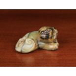 A Ming Period Jade Carving of Reclining Dog with scrolled tail, 2¼" (5.5 cm) in length.