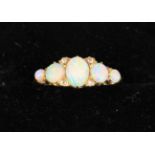 A Lady's 18 Carat Yellow Gold Ring set with five opals and four small diamonds flanking the central