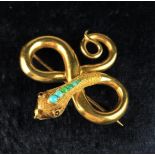 A Gold Snake Brooch inset with small turquoise beads and ruby eyes.