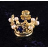 A Miniature Gold Crown set with small pearls and an inverted tear drop sapphire.