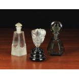 Three Art Deco Glass Scent Bottles: One of smoky quartz glass having a hexagonal flask and flat