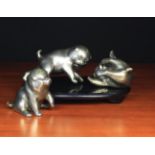 A Group of Three Japanese Silver Patinated Bronze Puppies depicted playing,