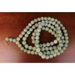 A Long String Necklace of Large turned Jade Beads 6ft 6" (198 cm) in length.