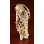 A 19th Century Signed Japanese Ivory Netsuke intricately carved as an elderly woman with bamboo