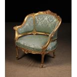 A 19th Century Upholstered Tub Armchair in a Carved Giltwood Frame.