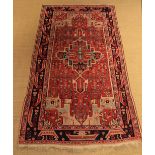 An Old Wool Claret Ground Carpet woven in turquoise, pale blue,