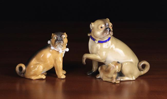 Two 19th Century Ceramic Pug Dog Ornaments: The largest modelled as a seated female with puppy