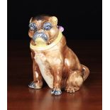 A 19th Century Majolica Pug Dog modelled seated wearing a yellow collar with pink bow & bells.