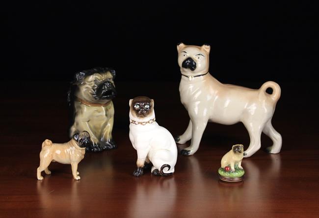 A Group of Five Ceramic Pug Dog Ornaments: A Staffordshire pug standing alert, 7¼" (18.