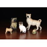 A Group of Five Ceramic Pug Dog Ornaments: A Staffordshire pug standing alert, 7¼" (18.