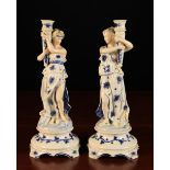 A Pair of Porcelain Figural Candlesticks modelled as classical nymphs in blue & white draped robes,